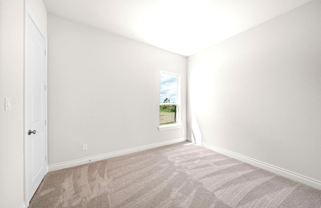 spare room featuring baseboards and carpet