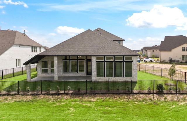rear view of property featuring a shingled roof, a fenced backyard, a yard, and a residential view
