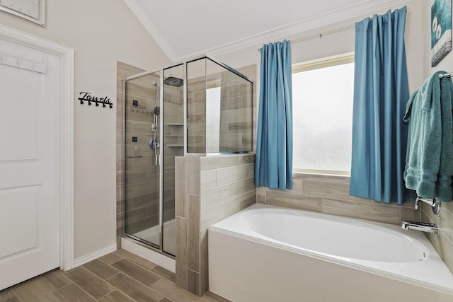 bathroom featuring plenty of natural light, separate shower and tub, lofted ceiling, and ornamental molding