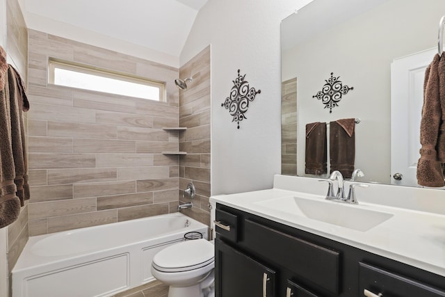 full bathroom with vanity, toilet, lofted ceiling, and tiled shower / bath combo