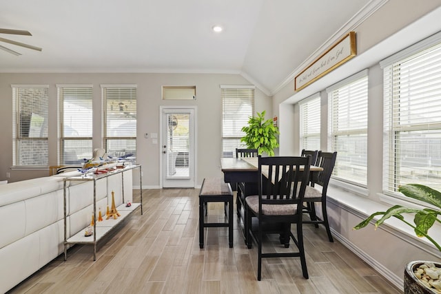 dining area featuring plenty of natural light, ornamental molding, vaulted ceiling, and light hardwood / wood-style flooring