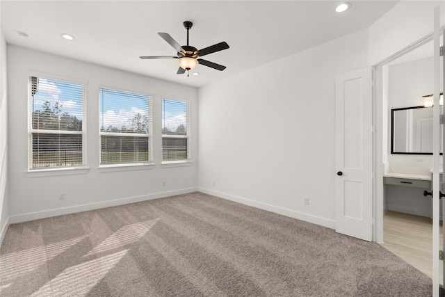 carpeted spare room featuring ceiling fan