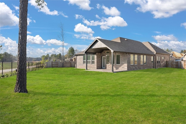 back of house featuring a fenced backyard, a patio, a lawn, and brick siding