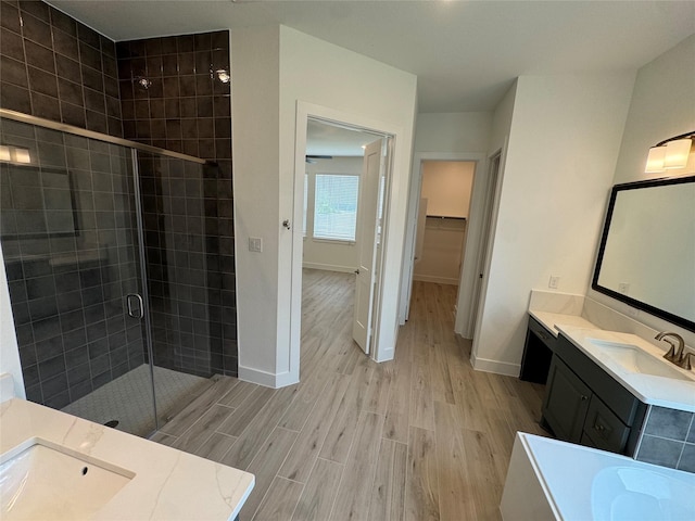 18101 Brennie Bird Ln, Conroe, TX 77302 - full bath featuring wood finished floors, a stall shower, vanity, baseboards, and a spacious closet