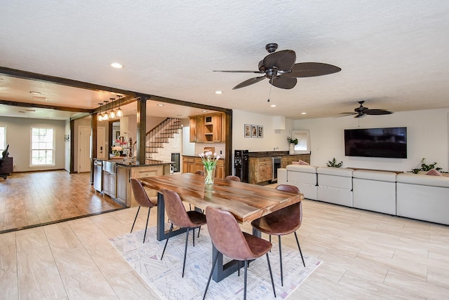 dining area featuring a textured ceiling, light hardwood / wood-style flooring, and ceiling fan