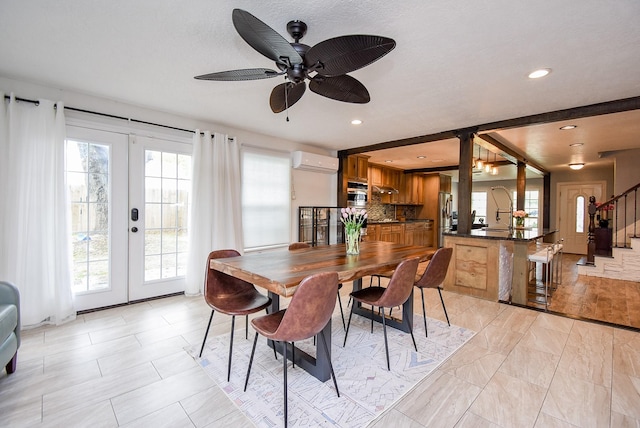 dining room with plenty of natural light, ceiling fan, an AC wall unit, and french doors