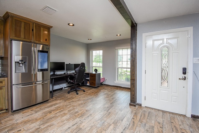 office area with beam ceiling and light hardwood / wood-style flooring