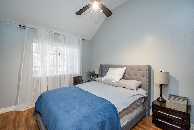 bedroom with ceiling fan, vaulted ceiling, and hardwood / wood-style flooring