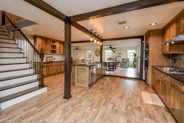 kitchen with ceiling fan, stainless steel appliances, beamed ceiling, backsplash, and light wood-type flooring