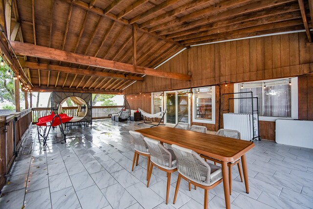 dining space featuring a notable chandelier, lofted ceiling, wooden walls, and wooden ceiling