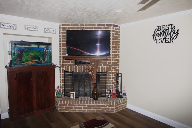 unfurnished living room featuring hardwood / wood-style floors, ornamental molding, a textured ceiling, and a brick fireplace