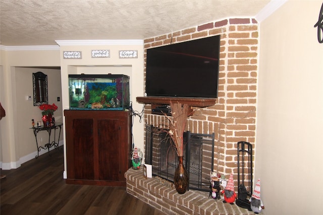 living room featuring a textured ceiling, dark hardwood / wood-style floors, a brick fireplace, and crown molding