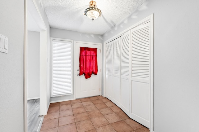 tiled entryway with a textured ceiling