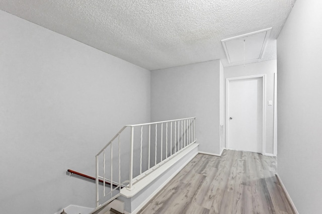 hallway featuring a textured ceiling and light wood-type flooring