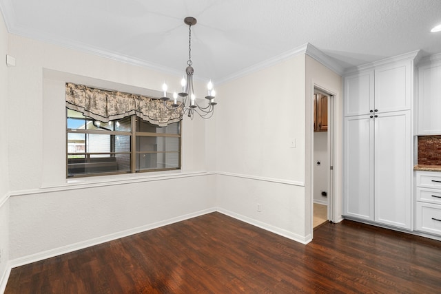 unfurnished dining area with a textured ceiling, crown molding, dark hardwood / wood-style floors, and a notable chandelier