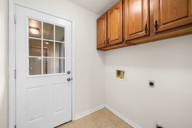 laundry area with electric dryer hookup, cabinets, washer hookup, and a textured ceiling