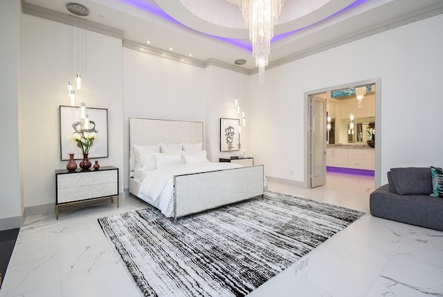 bedroom featuring ensuite bath, a raised ceiling, and an inviting chandelier