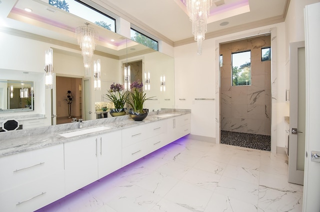 bathroom featuring a tile shower, a raised ceiling, a chandelier, vanity, and ornamental molding