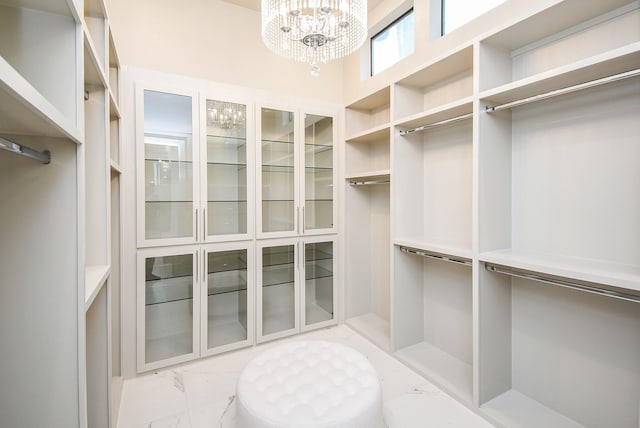 spacious closet featuring an inviting chandelier