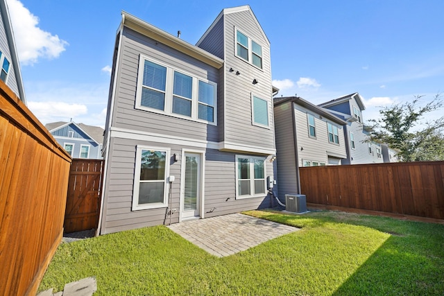 rear view of property with a yard, central AC, and a patio area