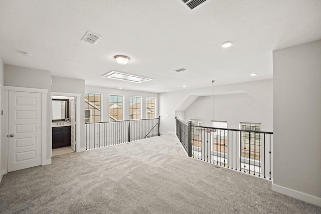 empty room with carpet flooring and a textured ceiling