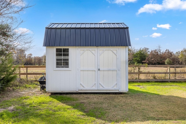 view of outdoor structure with a rural view and a yard