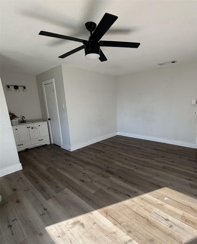 interior space featuring dark hardwood / wood-style flooring, ceiling fan, and sink