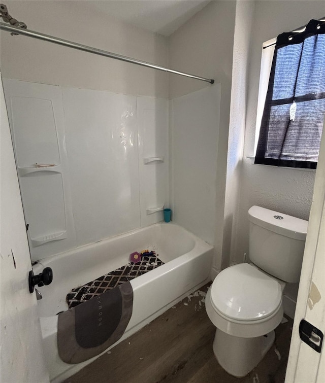 bathroom featuring toilet, wood-type flooring, and bathing tub / shower combination