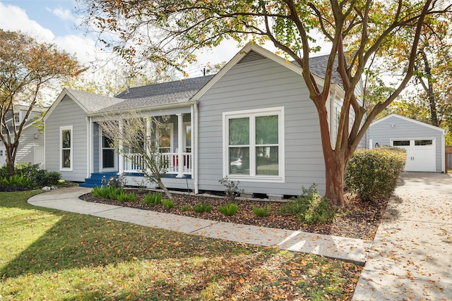 view of front of home with covered porch, a garage, an outdoor structure, and a front yard