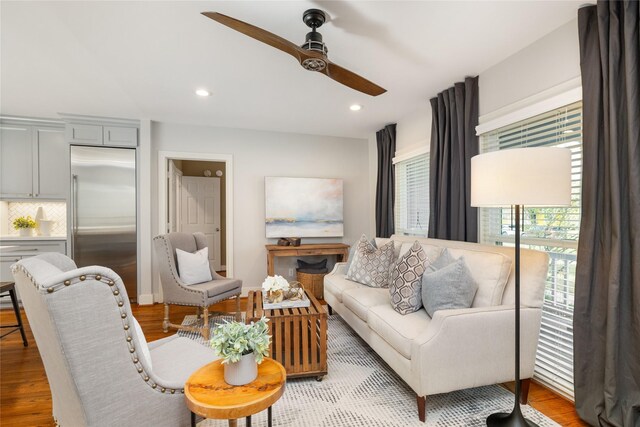 living room featuring ceiling fan and light hardwood / wood-style flooring