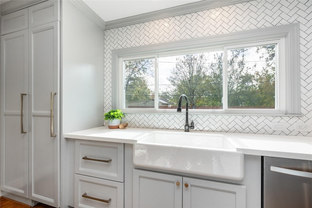 kitchen featuring backsplash, crown molding, sink, and stainless steel dishwasher