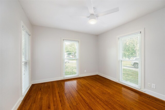 spare room with hardwood / wood-style flooring, ceiling fan, and a healthy amount of sunlight