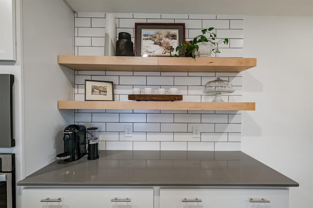 bar with decorative backsplash and white cabinetry