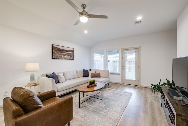 living room featuring ceiling fan, light wood-type flooring, and vaulted ceiling