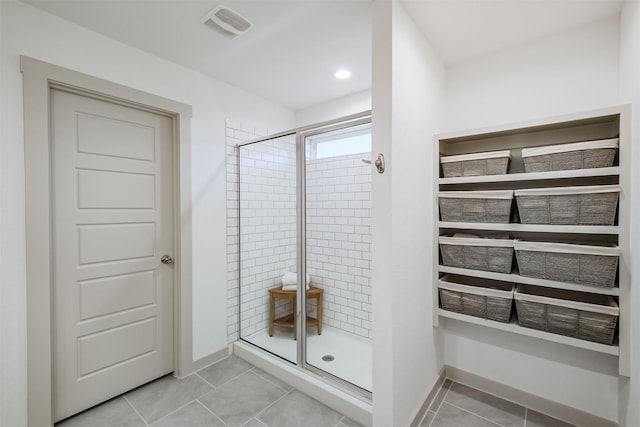 bathroom featuring tile patterned flooring and an enclosed shower