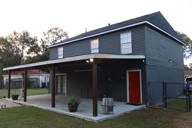 back of house featuring a patio area and a lawn