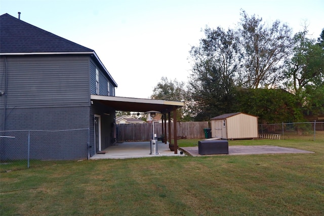 view of yard with a patio area, a fenced backyard, a storage unit, and an outdoor structure