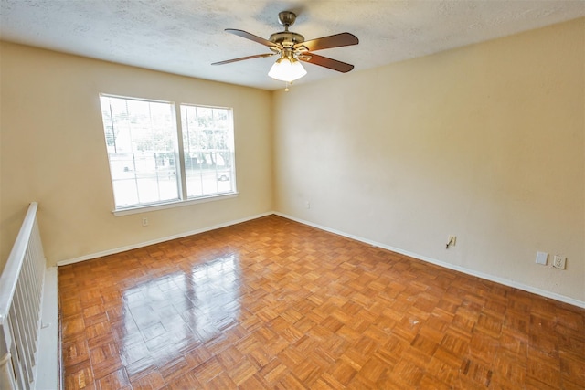 unfurnished room featuring a textured ceiling, ceiling fan, and baseboards