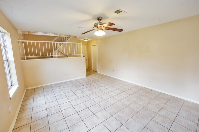 unfurnished room featuring visible vents, ceiling fan, stairway, and baseboards