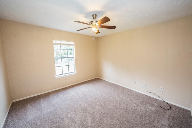 carpeted empty room featuring a textured ceiling, baseboards, and a ceiling fan