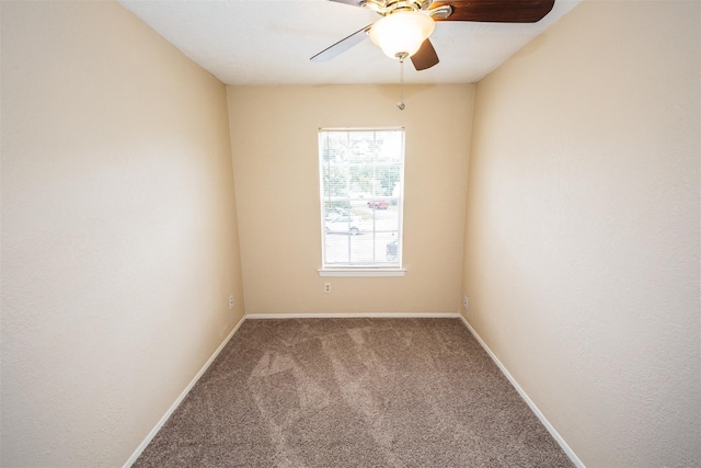 carpeted spare room with a ceiling fan and baseboards