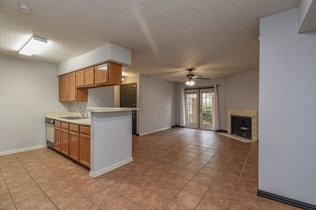 kitchen with ceiling fan, sink, light tile patterned flooring, and a textured ceiling