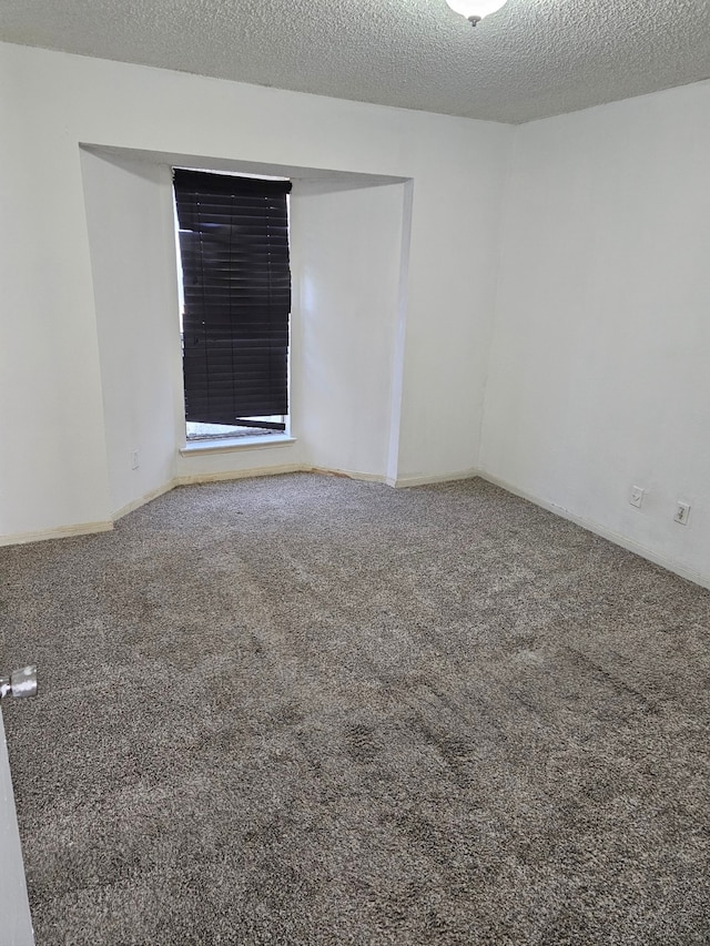 carpeted spare room with a textured ceiling