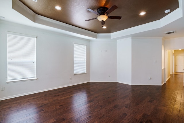 spare room with dark hardwood / wood-style floors, crown molding, and a tray ceiling