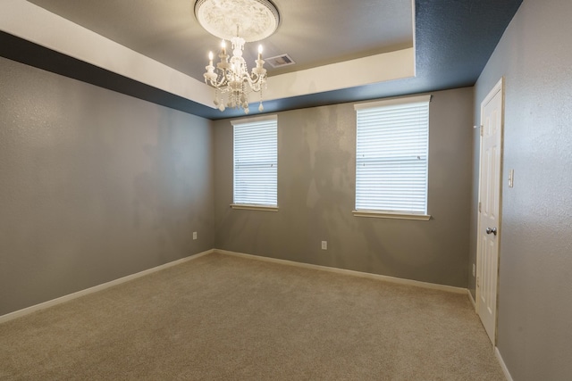 unfurnished room featuring carpet flooring and an inviting chandelier