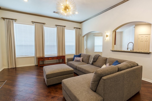 living room with an inviting chandelier, dark hardwood / wood-style floors, and ornamental molding