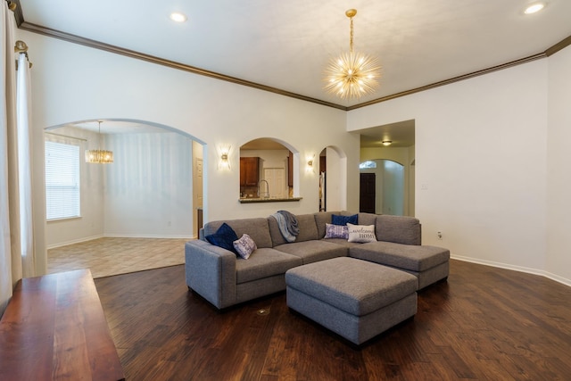 living room featuring a notable chandelier, crown molding, and dark wood-type flooring