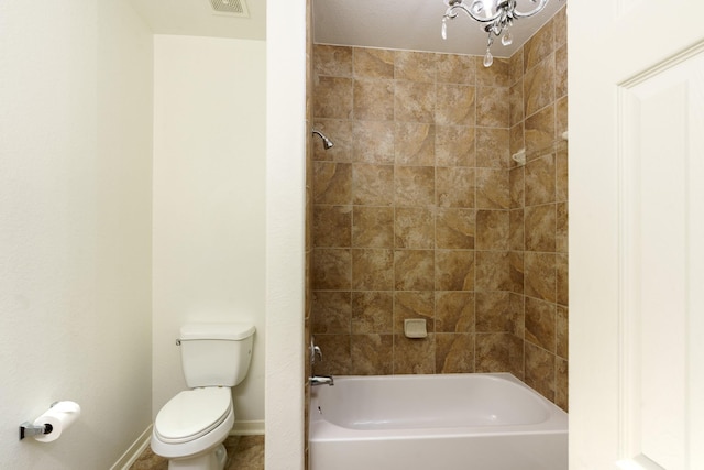 bathroom with tiled shower / bath combo and toilet