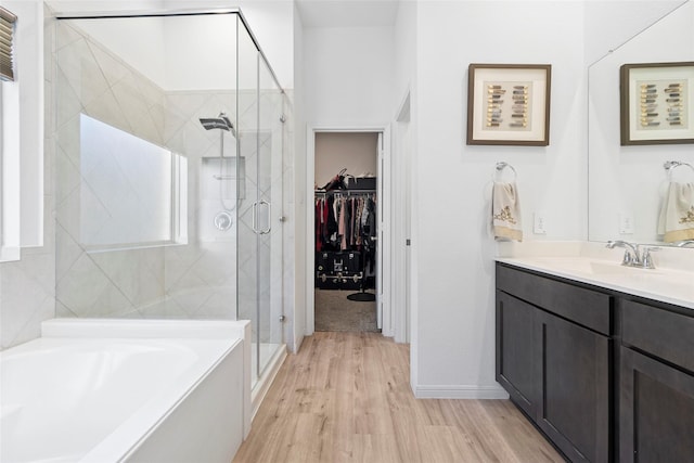 bathroom with hardwood / wood-style flooring, vanity, and independent shower and bath