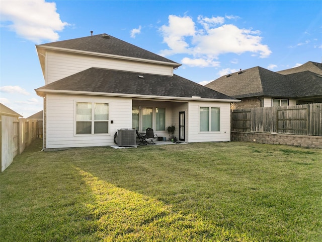 rear view of property featuring central air condition unit, a yard, and a patio